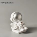 Figurine d'astronaute en décoration de science, en blanc avec casque argenté, idéale pour embellir un espace thématique ou une étagère de collection.