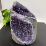 Améthyste géode naturelle avec cristaux violets brillants, idéale pour la décoration intérieure ou comme objet de collection.