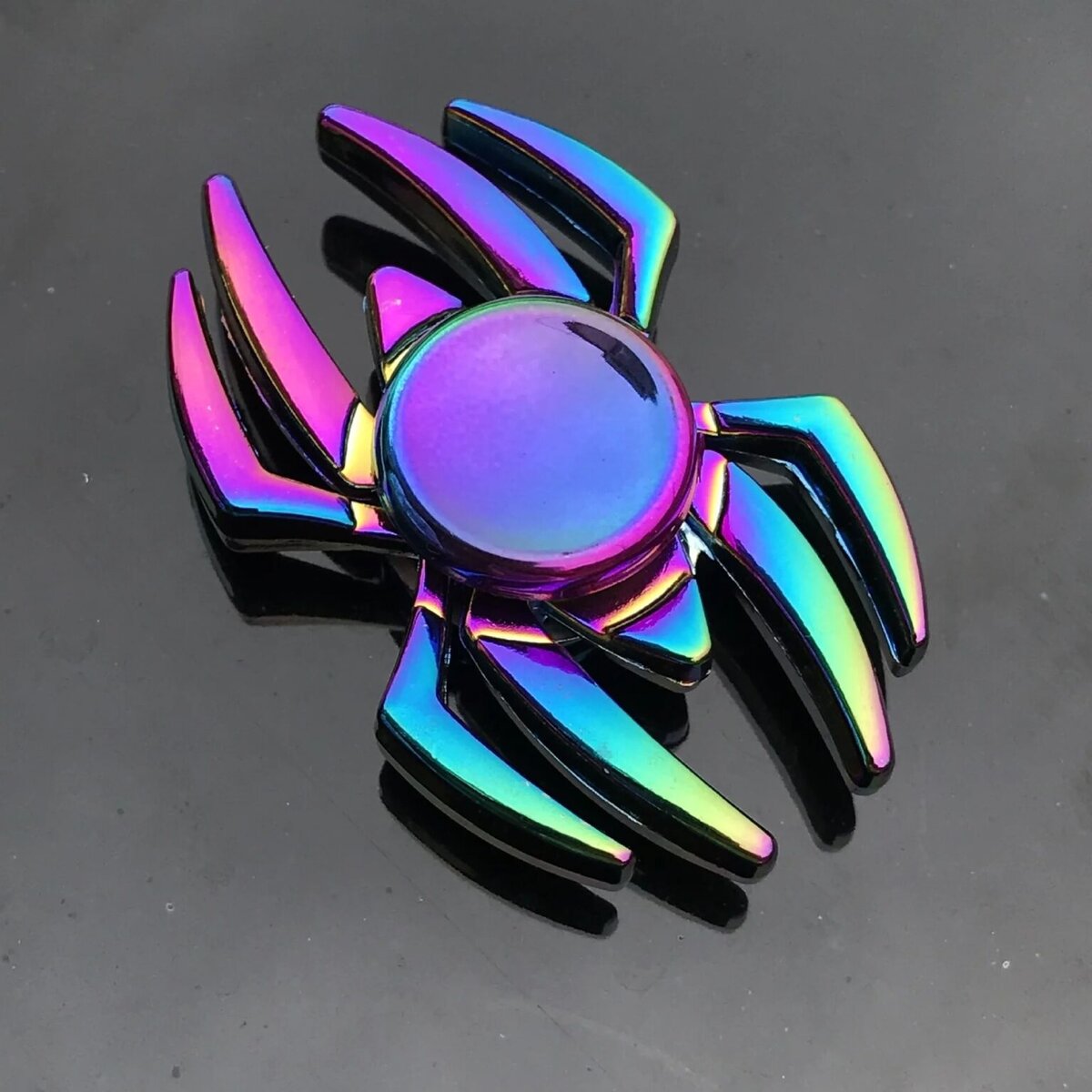 Accessoire de mode en forme de scorpion avec finition holographique multicolore.
