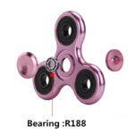 Fidget spinner en métal rose avec roulements à billes, idéal pour la détente et la concentration, avec un roulement à billes R188 visible.