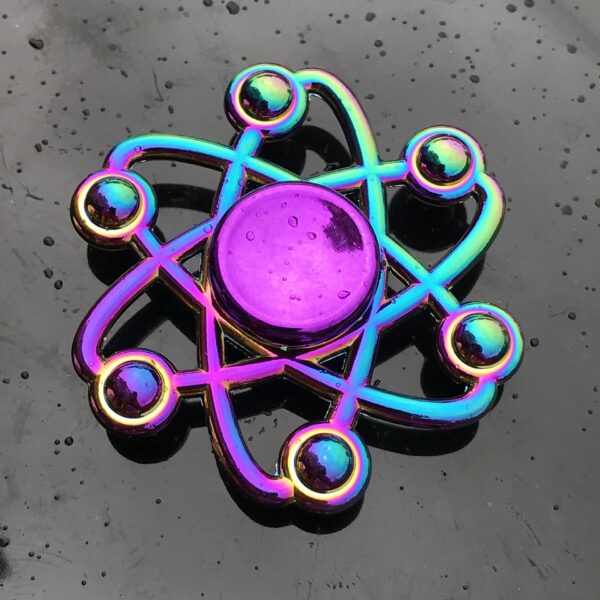 Atome en métal coloré avec effet holographique, symbole scientifique décoratif.