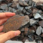 Pierre de météorite brute avec surface rugueuse et teinte sombre, idéale pour collectionneurs et amateurs de sciences naturelles.