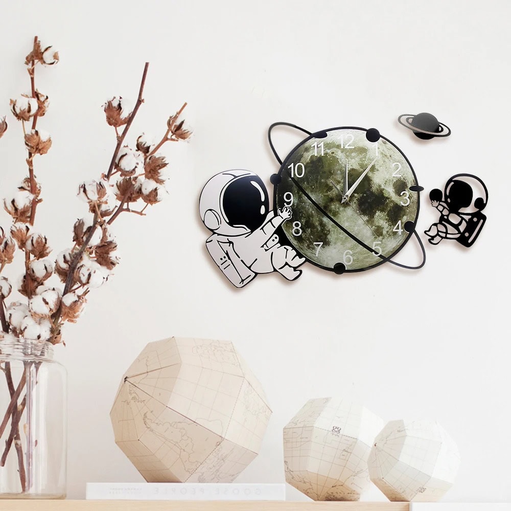 Horloge murale décorative avec astronautes et planète, inspirée de l'espace, idéale pour une décoration scientifique ou pour les amateurs d'astronomie.