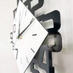Horloge murale moderne avec chiffres en forme de molécules et cadran blanc, idéale pour décoration de style scientifique ou éducatif.