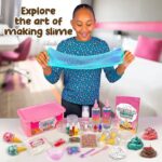 Jeune fille souriante manipulant du slime bleu, entourée de fournitures de création de slime coloré, dans un environnement lumineux et accueillant.