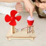 Jeu éducatif pour enfants avec un petit ventilateur rouge et une lampe de bureau, permettant d'apprendre la science et la technologie à travers une expérience pratique.