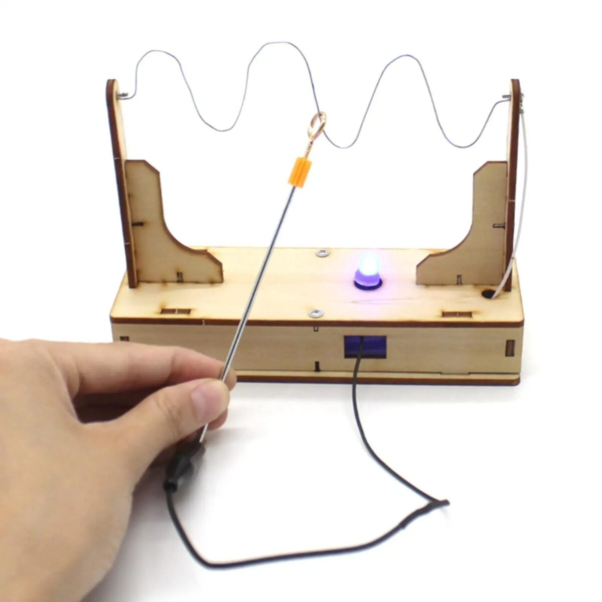 Montage d'une expérience électrique avec un générateur de courant, une bobine et une LED, illustrant un circuit simple pour démonstration scientifique.