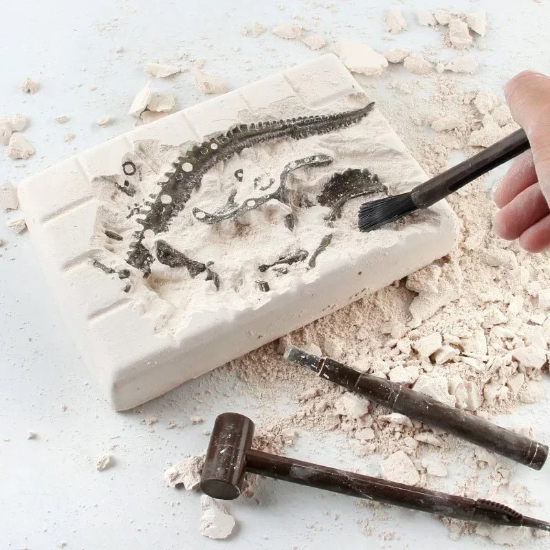 Fossile de dinosaure en plâtre avec pinceau, exposé sur une surface poussiéreuse, illustrant la paléontologie et la découverte scientifique.