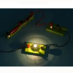 Circuit électrique avec ampoule allumée et composants scientifiques.