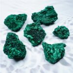 Pierre de malachite brute, vert vif, texture rugueuse.