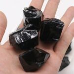 Pierre d'obsidienne noire brute, pierre naturelle aux propriétés protectrices et énergétiques, idéale pour la décoration ou la lithothérapie.