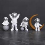 Vêtements d'astronautes en figurines décoratives pour la maison ou le bureau, avec un design moderne et ludique, parfaits pour les amateurs d'espace et de science.