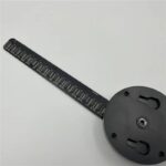 Règle de mesure pour microscope en plastique noir avec échelle en millimètres, utilisée pour la calibration et la mesure précise d'objets en microscopie.