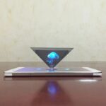 Projection holographique d'une méduse lumineuse flottant au-dessus d'un smartphone sur une surface en bois.