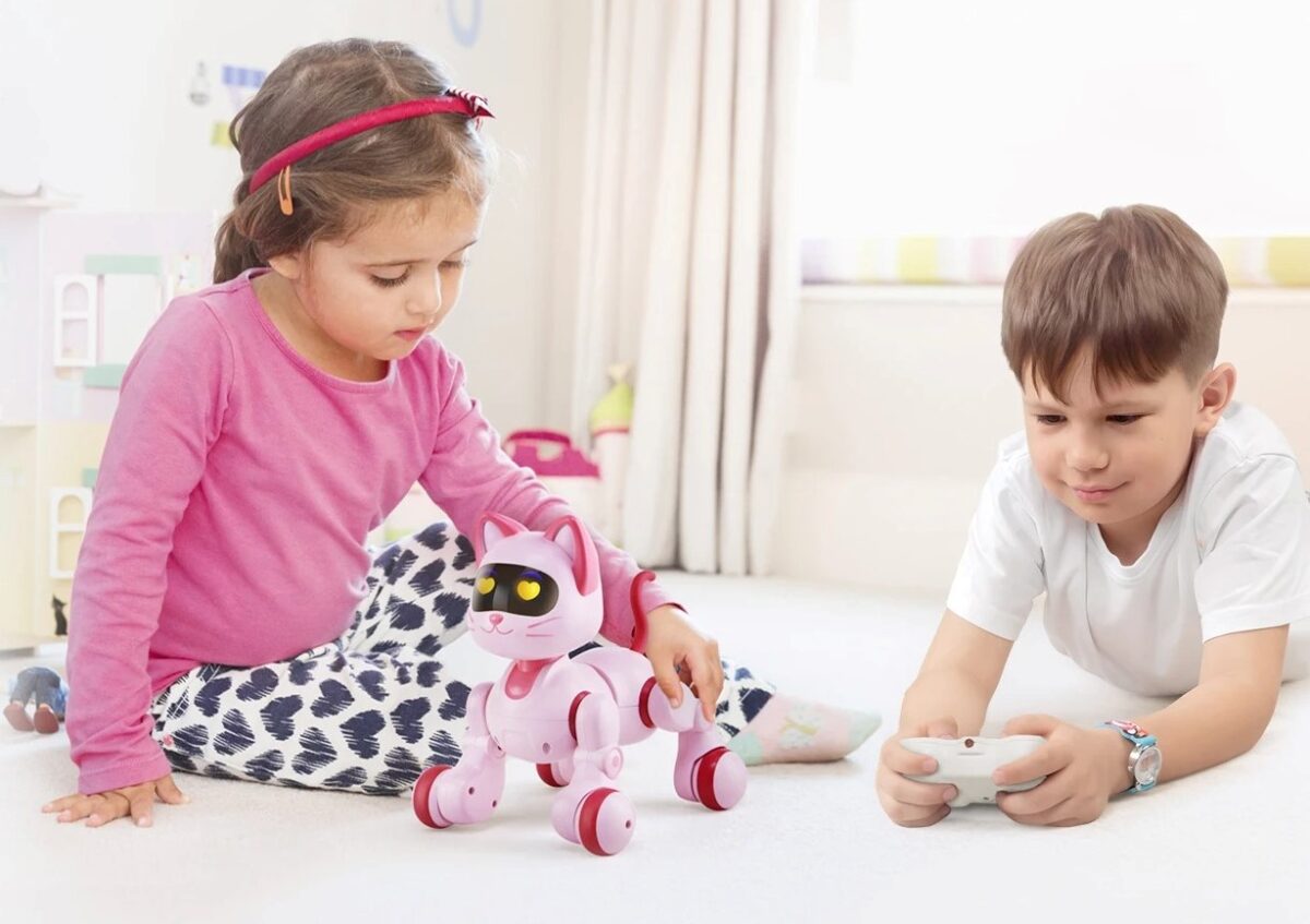 Deux enfants jouent avec un robot interactif rose et blanc dans une pièce lumineuse, stimulant leur curiosité et leur créativité à travers la technologie éducative.
