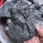 Pierre de météorite noire brute, texture rugueuse et naturelle. Parfaite pour la décoration scientifique ou comme objet de collection unique.