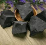 Pierre de charbon de bois noire, idéale pour décoration ou expériences scientifiques.