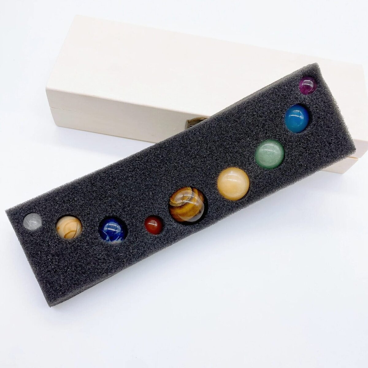 Ensemble de billes en marbre colorées, parfaites pour la décoration scientifique ou la collection. Diverses tailles et couleurs, présentées dans un support en mousse pour un rangement sécurisé.