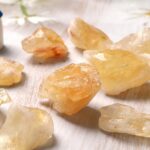 Gisements de cristaux de résine de pierre précieuse aux teintes chaudes, exposés sur une surface claire, illustrant la beauté naturelle et la diversité minérale.