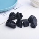 Pierres de charbon de bois noires, brutes et irrégulières, parfaites pour la décoration ou la filtration dans un environnement scientifique ou décoratif.