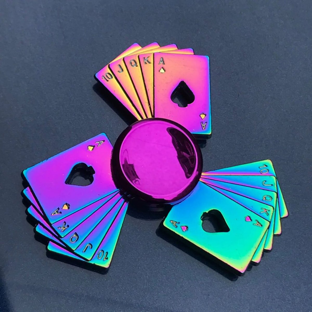 Jeu de cartes holographiques avec jokers colorés, disposés en cercle autour d'une boule violette, sur fond noir.