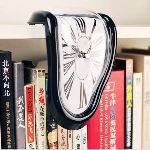 Un reloj de pared con diseño de reloj derretido, colocado entre libros en una estantería.