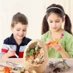 Deux enfants découvrent un œuf de dinosaure en plastique avec des figurines de dinosaures à l'intérieur, simulant une excavation scientifique éducative.