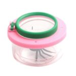 Loupe de poche avec araignée en plastique, idéale pour l'observation de petits insectes ou objets, avec un cadre coloré rose et vert, et un compartiment transparent.