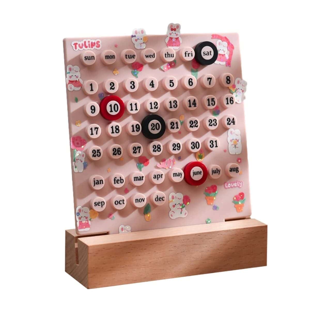 Un calendrier mural en bois avec des boutons rotatifs pour indiquer les jours, mois et dates, décoré de motifs mignons de lapins et fleurs.