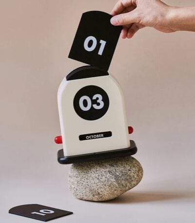 Calendrier original en forme de machine à écrire vintage avec affichage numérique, posé sur une pierre, pour une décoration scientifique ou rétro.