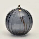 Vase en verre gris avec rayures noires, design élégant et moderne, parfait pour la décoration intérieure ou comme objet de collection scientifique.