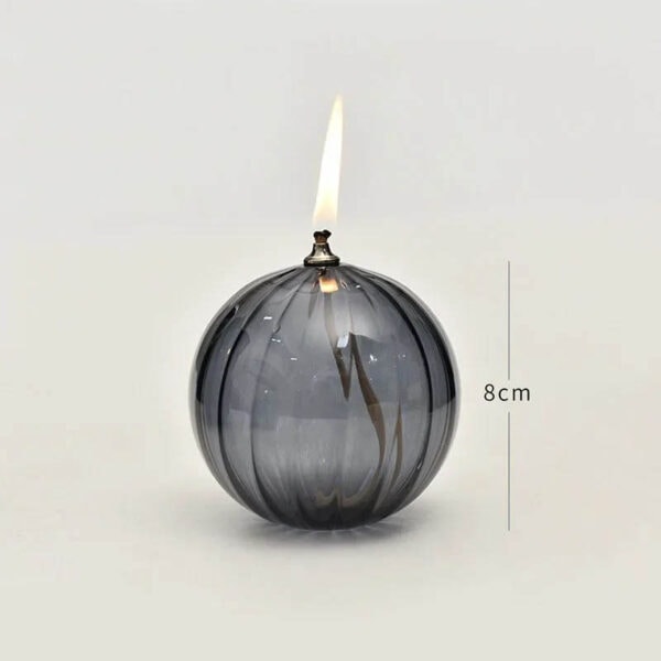 Vase en verre sphérique avec bougie allumée, hauteur de 8 cm, décoration de style scientifique ou moderne.