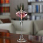 Vase de laboratoire en verre contenant une bougie allumée, utilisé comme décoration scientifique ou pour expériences.