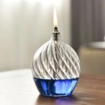 Bougie scientifique en forme de flacon avec flamme allumée, décoration originale pour un intérieur moderne ou un espace dédié à la science et à la décoration.