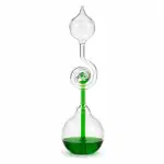 Pipette de laboratoire en verre contenant un liquide vert, utilisée pour des expériences scientifiques ou des démonstrations éducatives.