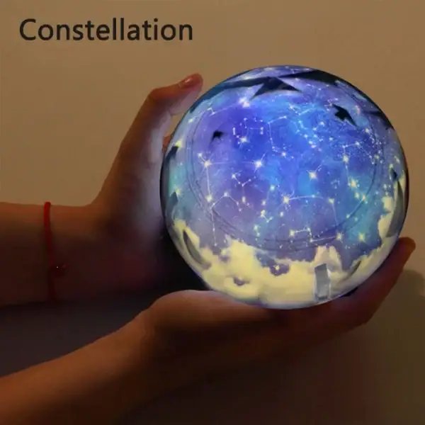 Boule lumineuse représentant une constellation d'étoiles avec un ciel étoilé et des constellations visibles, tenue dans une main pour un effet magique et décoratif.