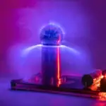 Boule de plasma colorée avec éclairs lumineux, sur support en métal, créant un effet visuel captivant et scientifique.