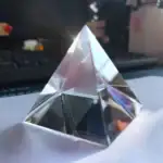 Pyramide en cristal transparent avec reflets lumineux, idéale pour la décoration scientifique ou comme objet de collection.