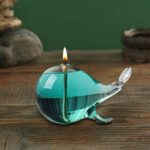 Lampe poisson en verre soufflé avec bougie allumée, idéale pour la décoration scientifique ou marine.