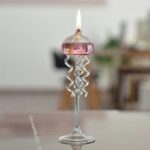 Bougie décorative en forme de méduse en verre avec flamme allumée, idéale pour une décoration originale et scientifique.