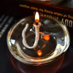 Bougie de laboratoire allumée avec flamme vive, utilisée pour des expériences scientifiques ou décoratives dans un contexte scientifique.