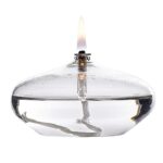 Lampe à huile en verre transparent avec flamme allumée, idéale pour la décoration scientifique ou éducative.