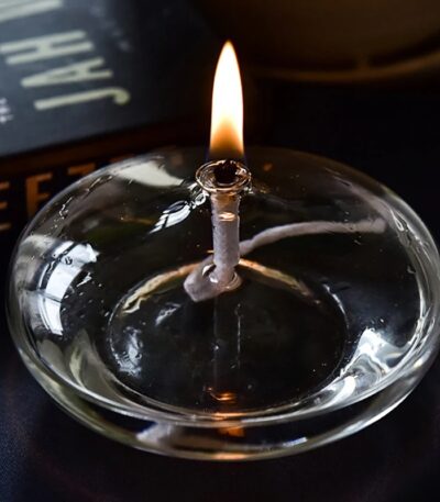 Bougie de laboratoire en verre avec flamme allumée, idéale pour la décoration scientifique ou pour créer une ambiance chaleureuse dans un espace de travail.