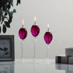 Vases décoratifs en forme de bougies avec flammes en verre violet, parfaits pour une décoration élégante et moderne.