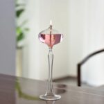 Vase en verre soufflé avec bougie allumée, design élégant et moderne, parfait pour la décoration intérieure ou comme objet de collection scientifique.