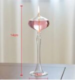 Bougeoir en verre transparent contenant une bougie allumée, mesurant 14 cm de hauteur, idéal pour la décoration de table ou ambiance chaleureuse.