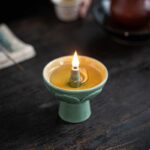 Bougie en céramique avec flamme allumée, idéale pour la décoration scientifique ou pour créer une ambiance chaleureuse dans un espace dédié à la science.