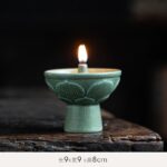 Bougeoir en céramique vert avec flamme allumée, idéal pour décoration scientifique ou ambiance chaleureuse.