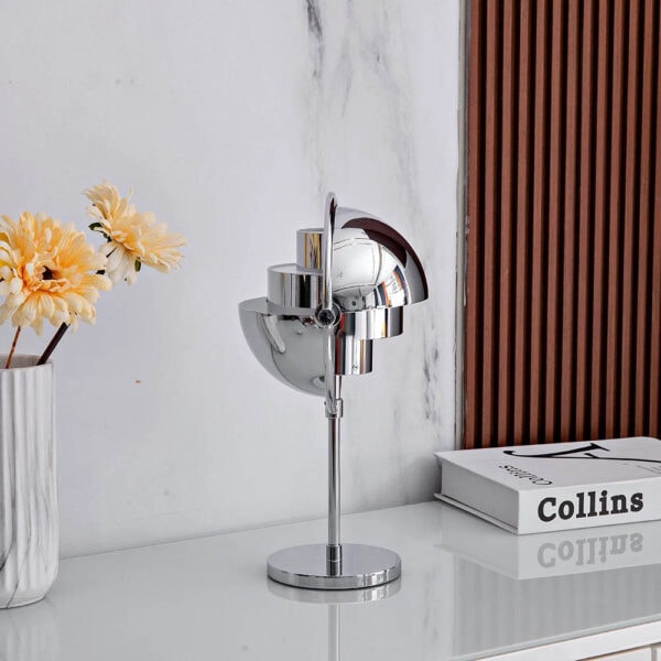 Lampe de bureau design en métal chromé avec une finition brillante, idéale pour une décoration contemporaine et élégante dans un espace de travail ou un salon.