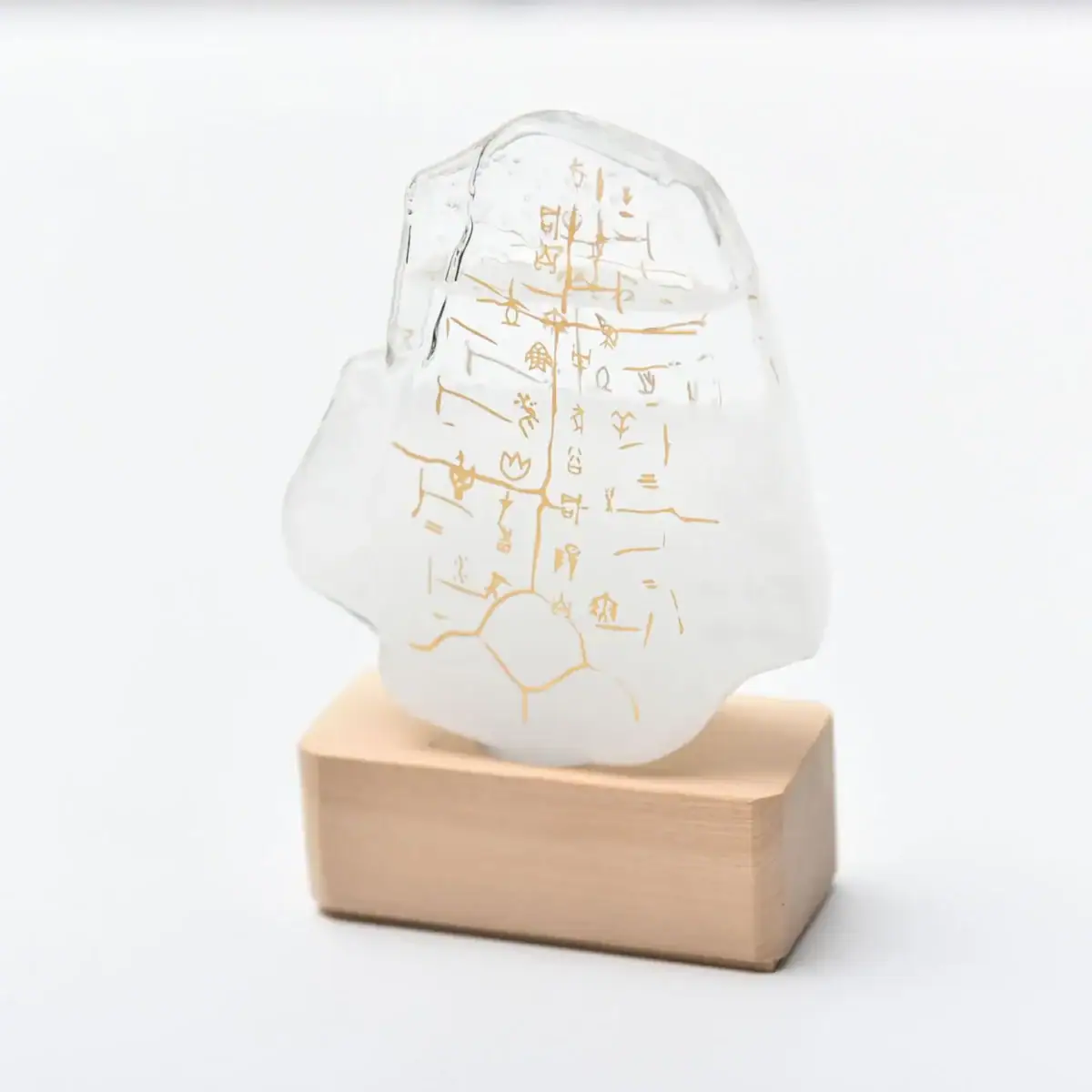 Pierre à écriture en verre avec inscriptions anciennes gravées, posée sur un socle en bois, décoration scientifique unique et élégante.